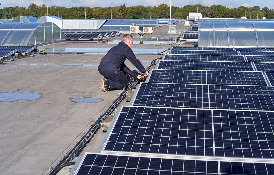 Technicien contrôlant le fonctionnement d'une installation de panneaux solaires avec un testeur de Fluke.